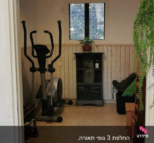 חדר עם מנורת תלייה, חלון ומכשיר כושר